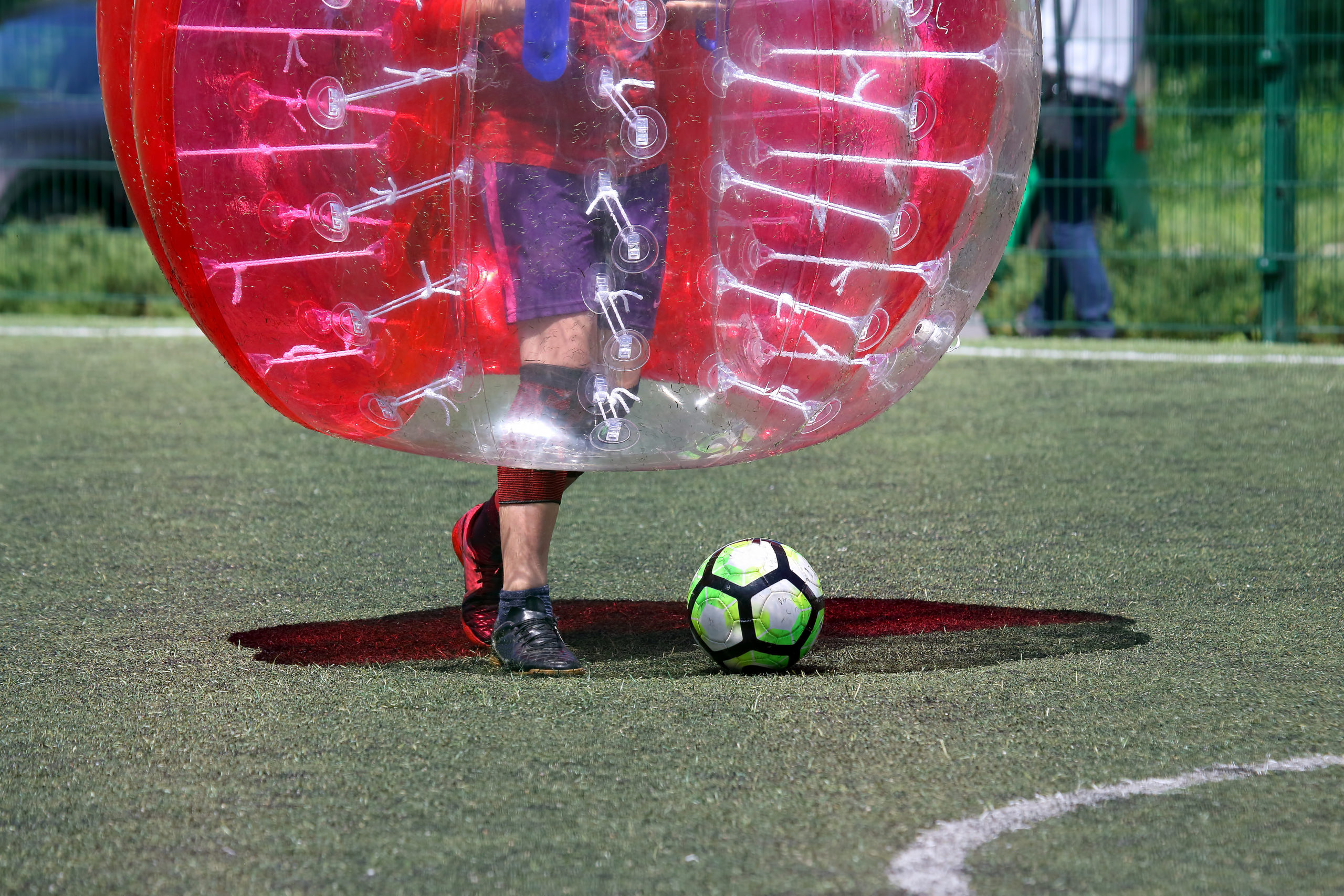 Jugador de fútbol burbuja corriendo detrás del balón